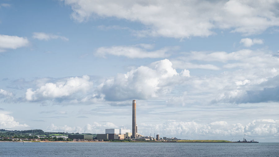 Large factory with tall chimney and industrial harbour on the northern ireland coast