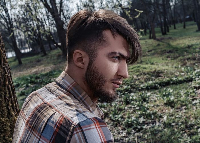 Thoughtful man looking away in forest