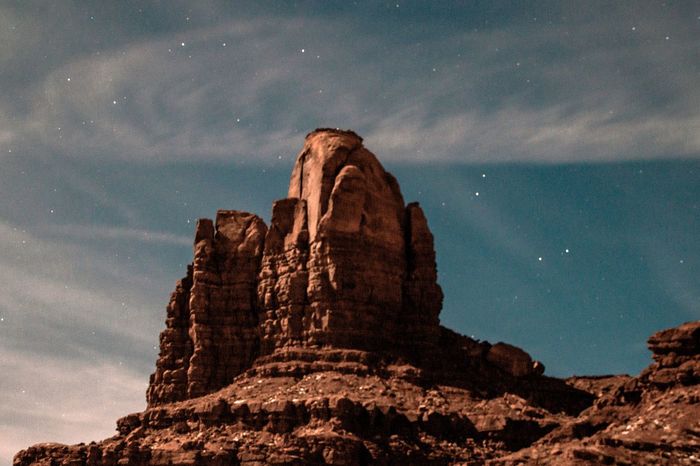 LOW ANGLE VIEW OF ROCK FORMATION AGAINST SKY AT NIGHT