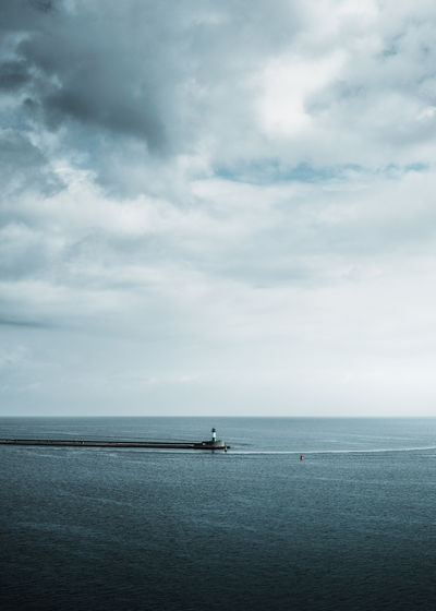 Scenic view of sea and lighthouse against sky