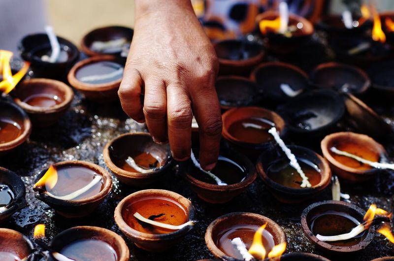Cropped hand adjusting diya
