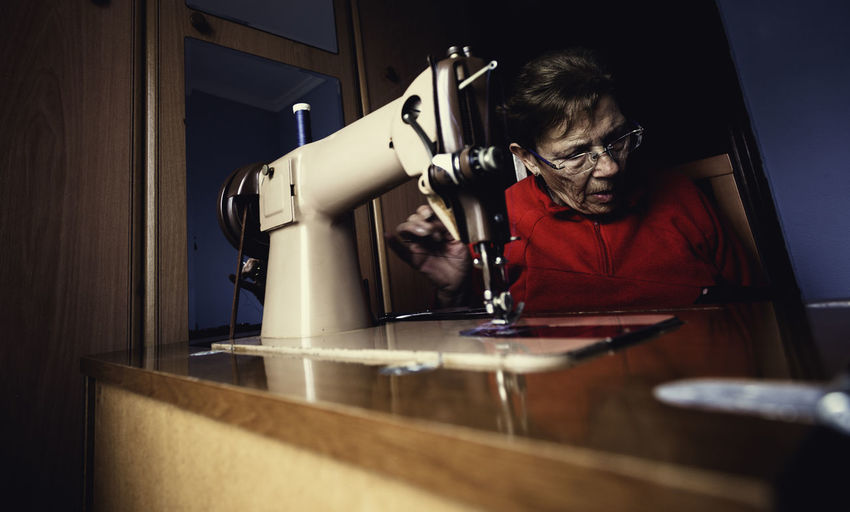 Woman by sewing machine at home