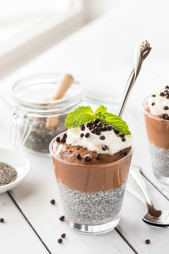 A chocolate mousse chia pudding cup against a bright sunny window.
