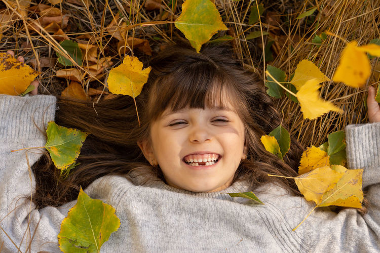 Portrait of happy boy lying on leaves