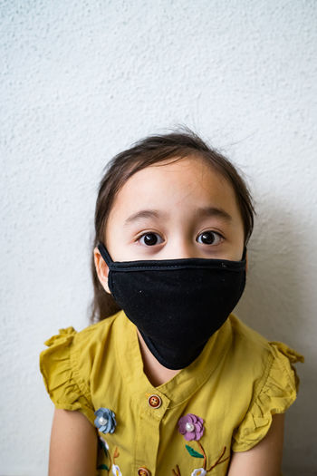 Asian young child is wearing hygienic reusable face mask to prevent the virus. new normal.