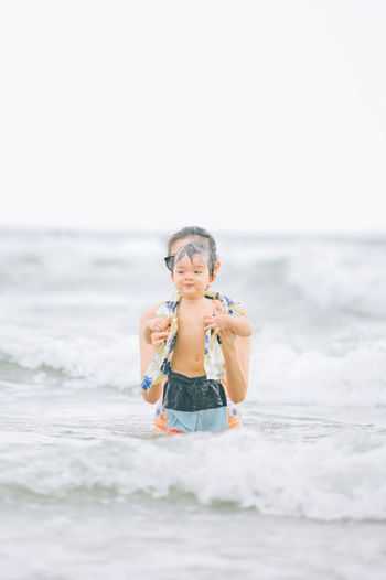Portrait of boy playing with ball at beach