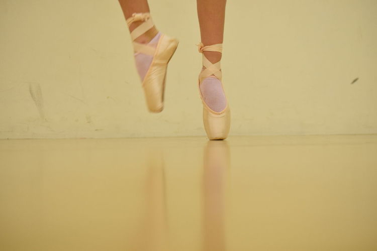 Low section of ballet dancer tiptoeing on floor