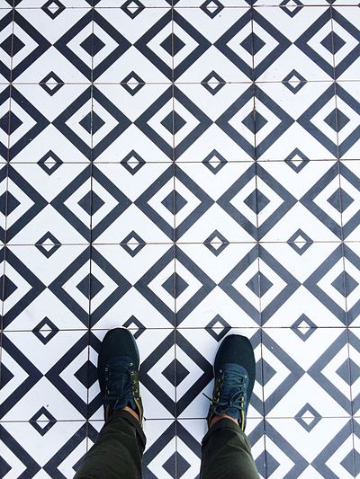 Low section of man standing on tiled floor