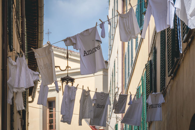Clothes hung to dry in the sun with various writings in italian love, history, fear