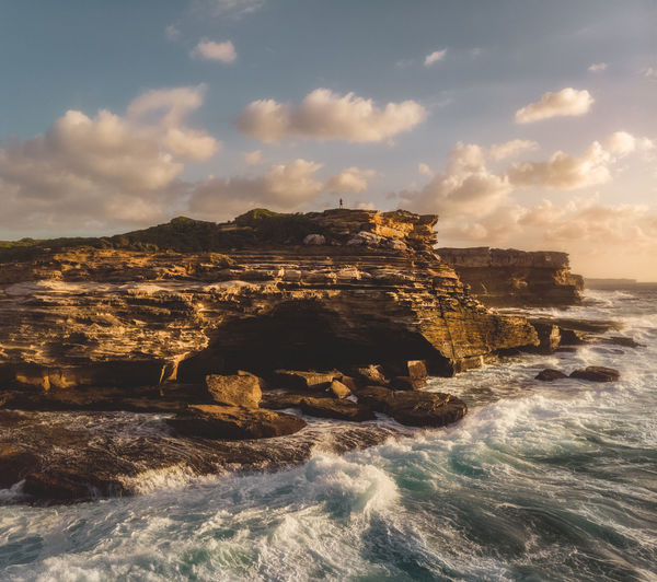 Scenic view of dramatic coastal cliff in morning light with atmospheric cloudscape