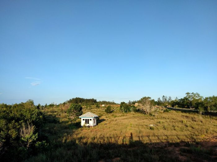 House on field against clear sky
