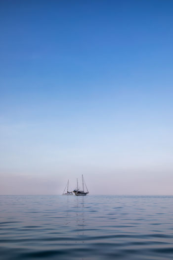 Sailboat in sea against blue sky