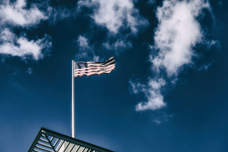 Low angle view of american flag against blue sky
