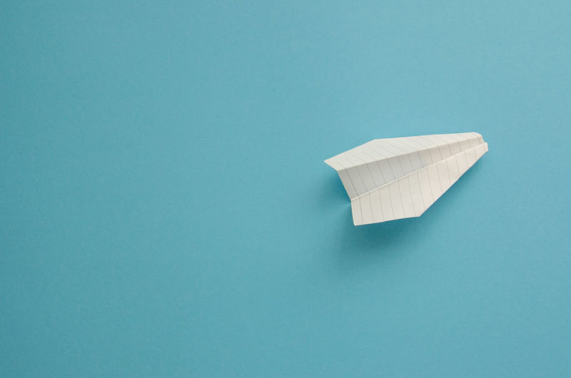 Directly above shot of paper boat against blue background