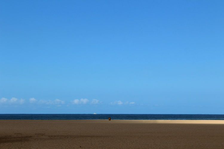 Scenic view of beach against blue sky