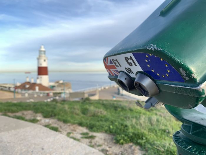 Binoculars and europa point lighthouse with european and british flags