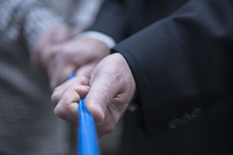 Midsection of man and woman holding rope