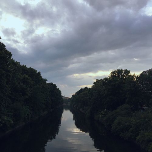View of canal against cloudy sky