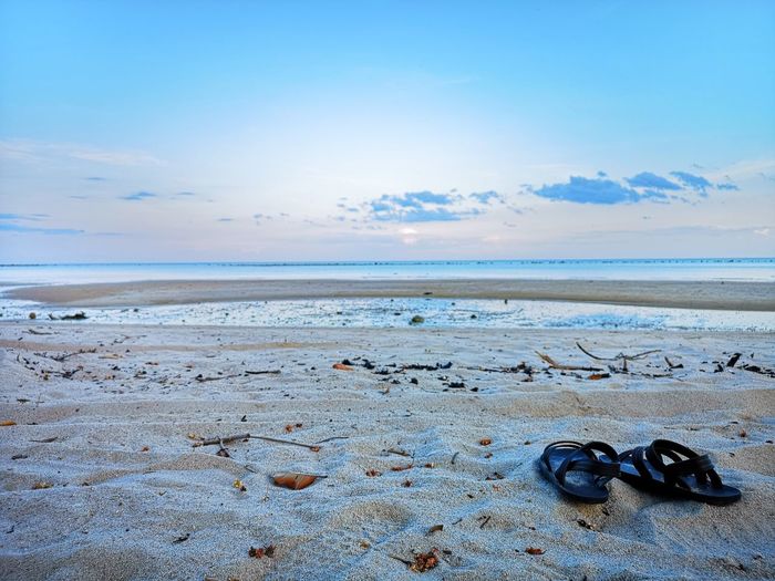 High angle view of shoes on beach against sky