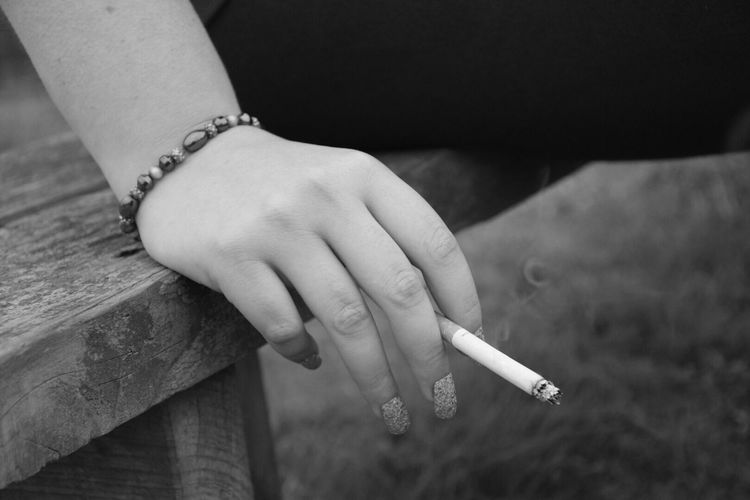 Cropped image of woman holding cigarette