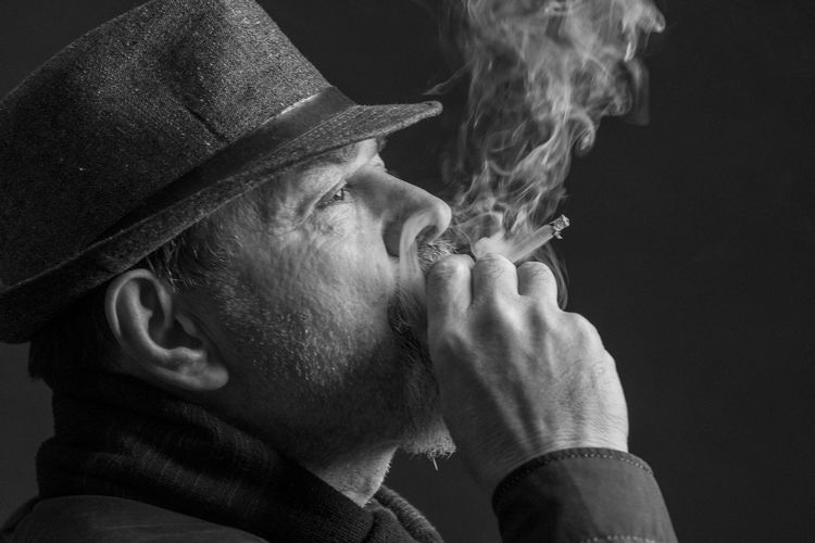 Portrait of man wearing hat against black background