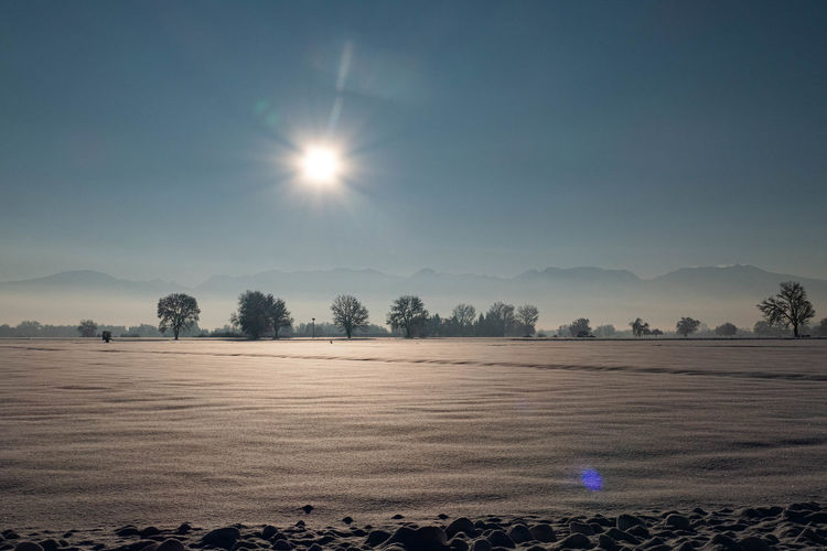 Scenic view of field against sky during winter