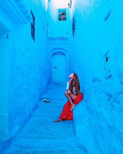 Woman standing against blue wall