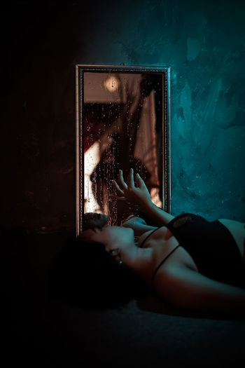 Woman hand holding glass window in dark room