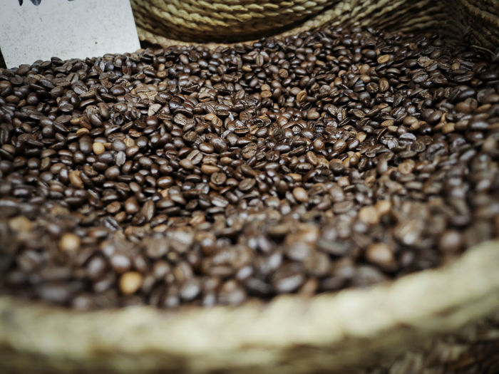 Close-up of roasted coffee beans in wicker basket in store
