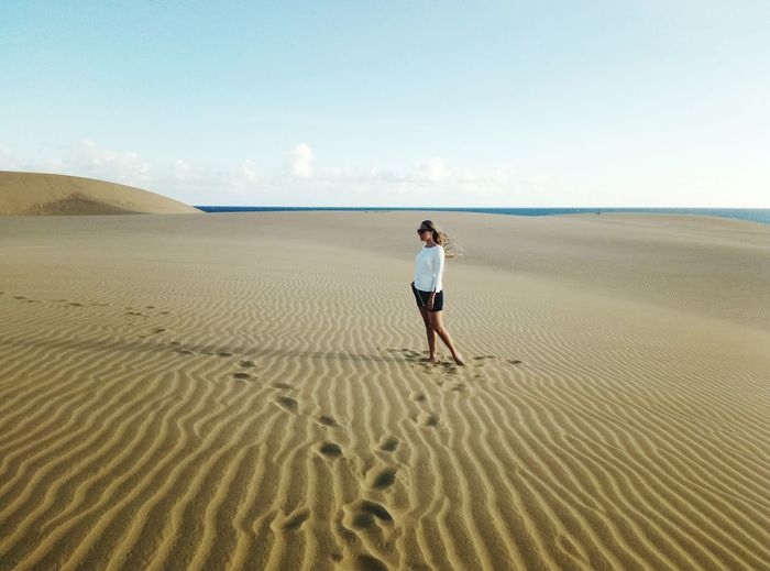 Woman standing on sand dune
