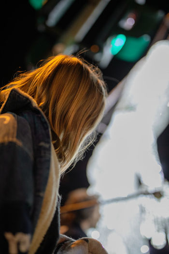 Fashionable young woman in city at night
