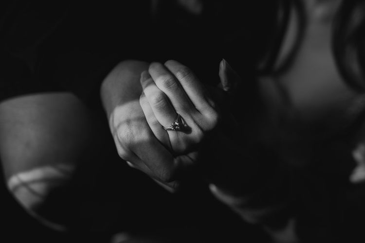 Cropped hands of couple with engagement ring in darkroom