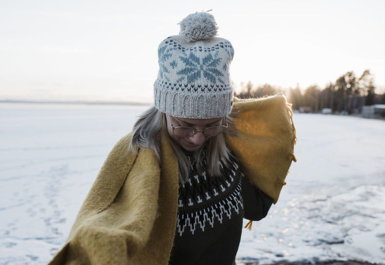 Portrait of woman holding scarf whilst walking on a frozen lake