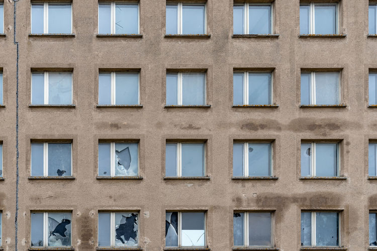 Full frame of array of windows with broken glass in old building facade. island of rugen.