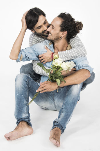 Young couple kissing against white background