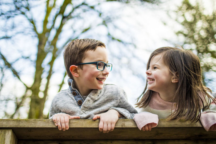 Playful portrait of boy and girl on railing.