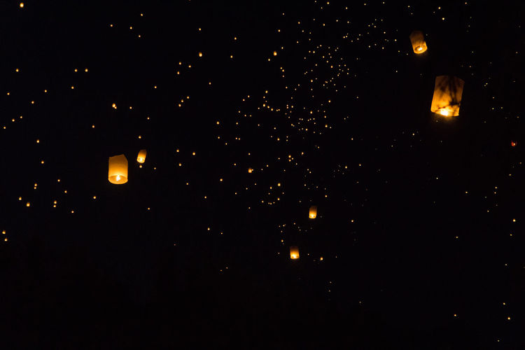 Low angle view of illuminated lantern against sky at night