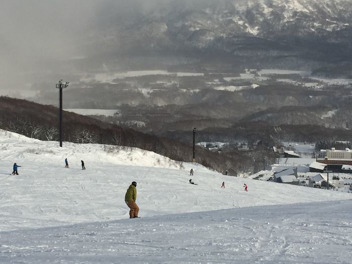 People skiing on field during winter
