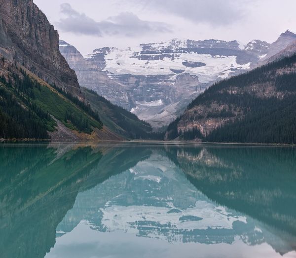Scenic view of lake and snowcapped mountains against sky