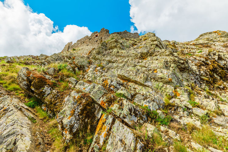 Low angle view of rocky mountains against sky