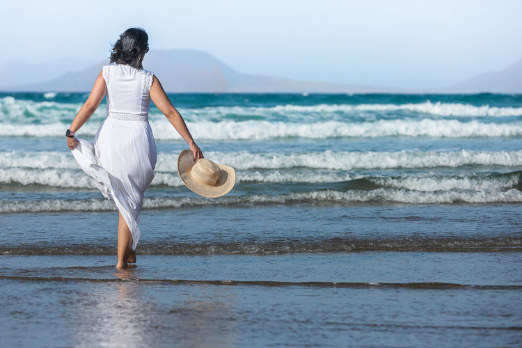 Side view of woman standing at beach