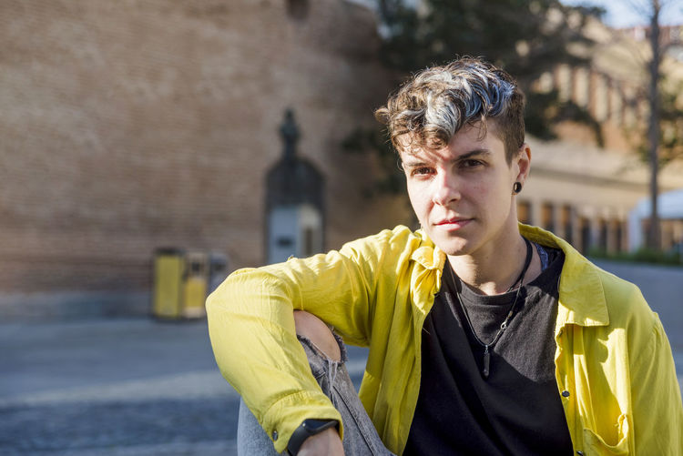 Portrait of young man looking away while standing outdoors