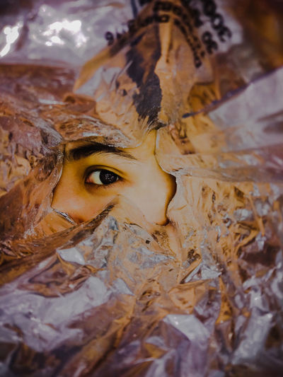 Close-up of human eye seen through foil