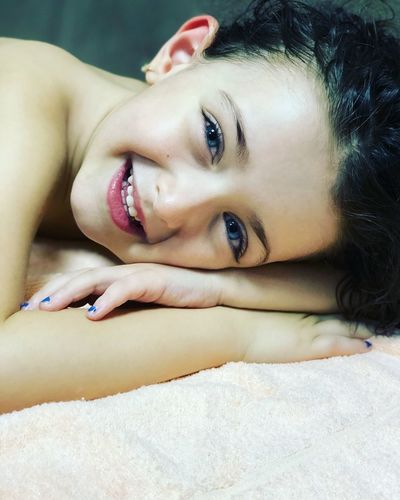 Close-up portrait of cute girl on bed