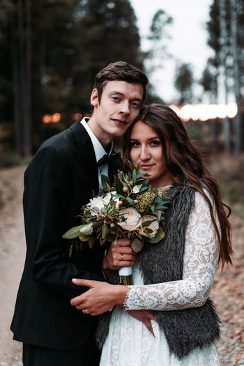 Portrait of newlywed young couple standing outdoors