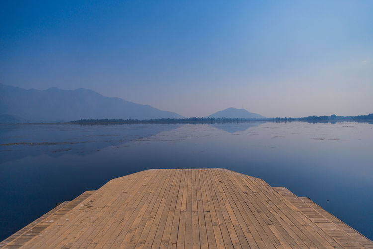 Scenic view of lake against clear blue sky
