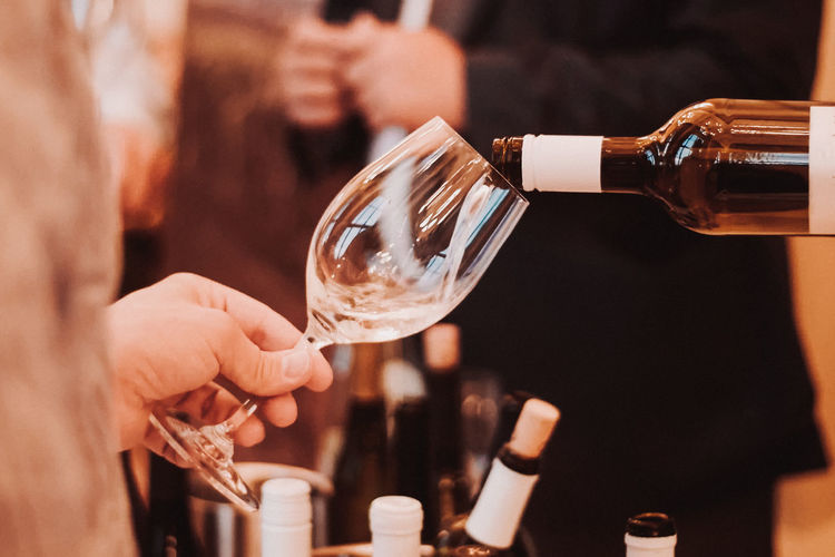 Cropped hand holding wineglass at restaurant