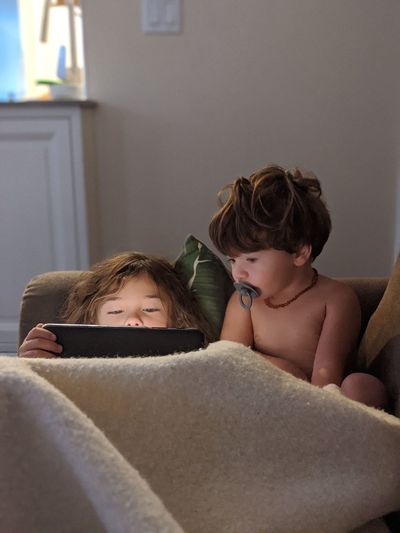 Portrait of brothers watching videos