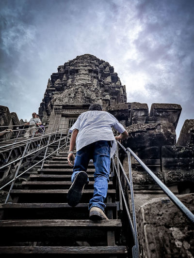 Low angle view of man on staircase against sky