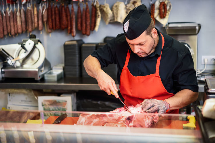 Butcher cutting meat in shop